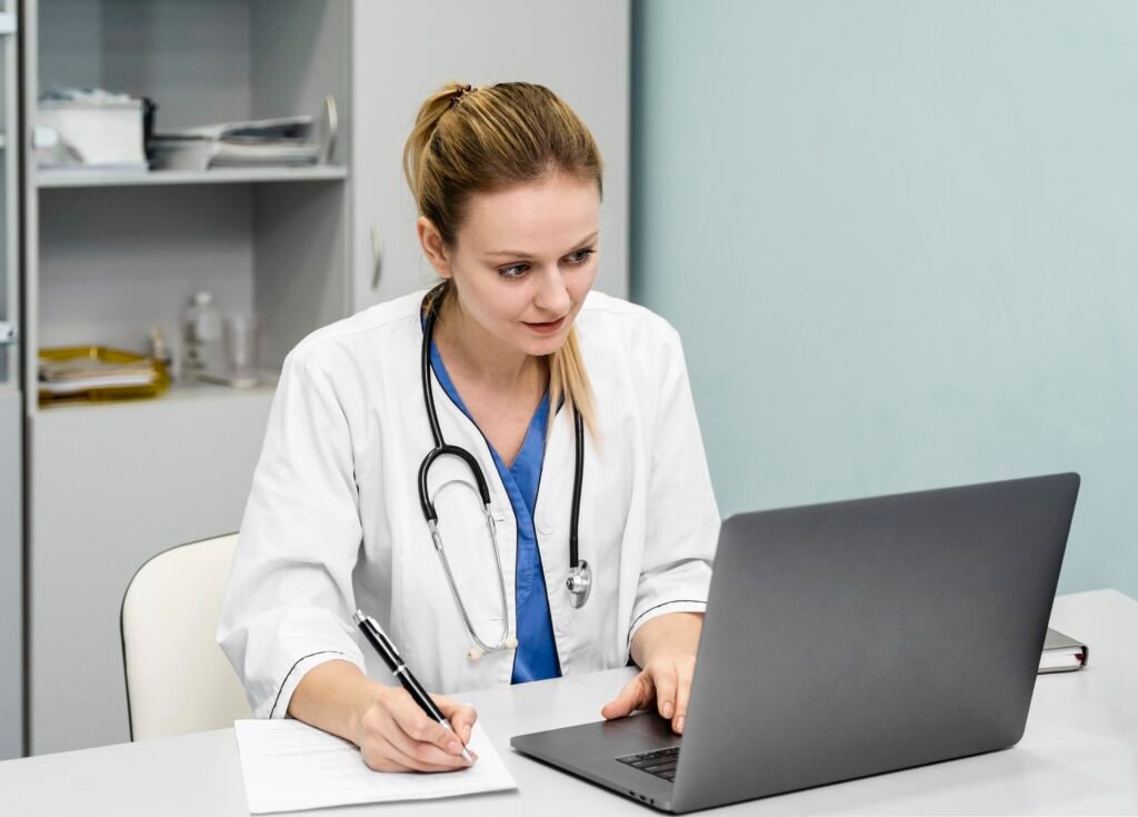 A doctor consulting a patient on a laptop screen.